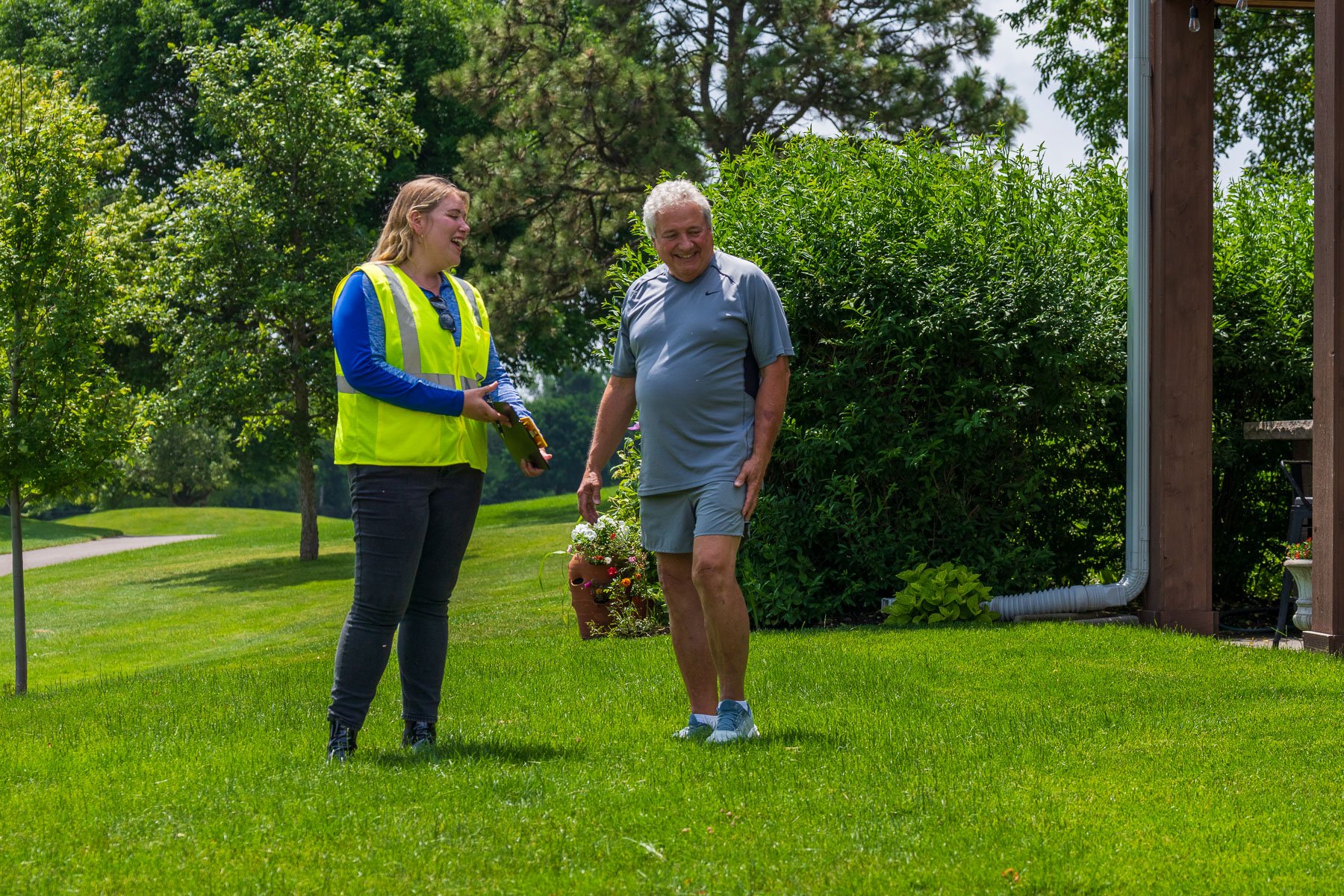 account manager talking to homeowner green lawn