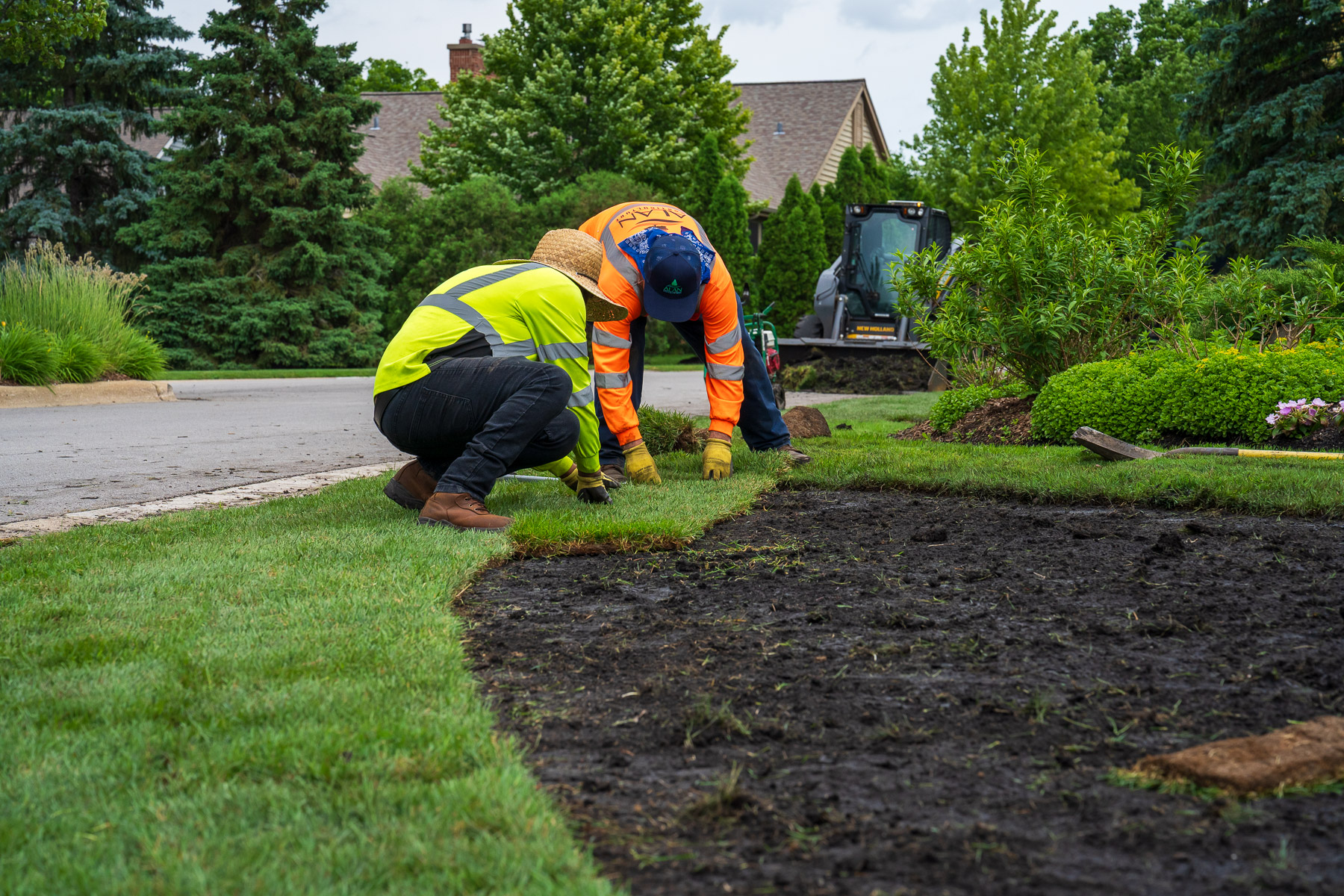 crew spreading out new rolls of sod 1